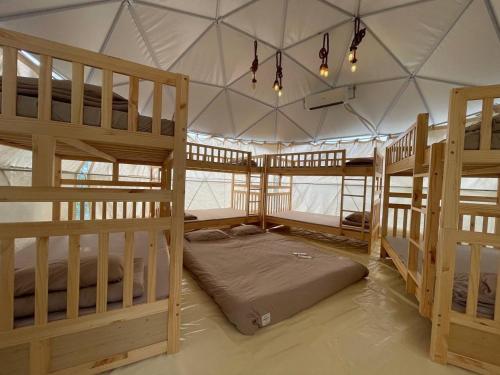 a room with three bunk beds in a tent at Tropical eGlamping in Tân Phú