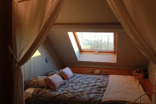 een slaapkamer met een bed en een raam bij L'Ancienne Cure in Besain