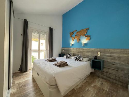 1 dormitorio con 1 cama grande y pared azul en Canarian Green Oasis by luca properties gran canaria en Maspalomas