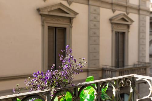 a bunch of purple flowers sitting on a fence at Mint - Van Gogh - Dome Cathedral in Milan