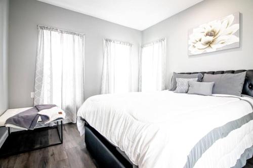 een witte slaapkamer met een groot bed en een raam bij Modern 1 Bedroom Apartment close Falls and Casino in Niagara Falls