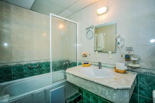 a bathroom with a sink and a shower and a mirror at Villas Elenite in Elenite