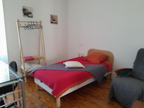 1 dormitorio pequeño con 1 cama y 1 silla en bel appartement en Combronde