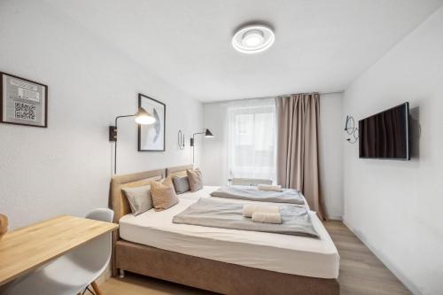 ein Schlafzimmer mit einem großen Bett und einem Schreibtisch in der Unterkunft Sali-Bayreuth SB19 Komfortable Wohnung in der Nähe des Zentrums in Bayreuth