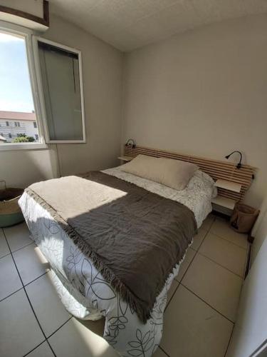 une chambre avec un lit dans une pièce avec une fenêtre dans l'établissement A 50 m de la plage centrale, à Soorts-Hossegor