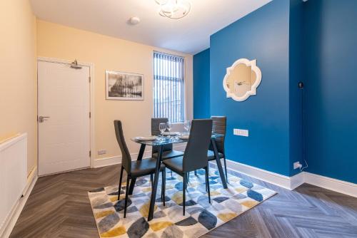 a dining room with blue walls and a table and chairs at 2 Bedroom House in the Heart of Leicester in Leicester