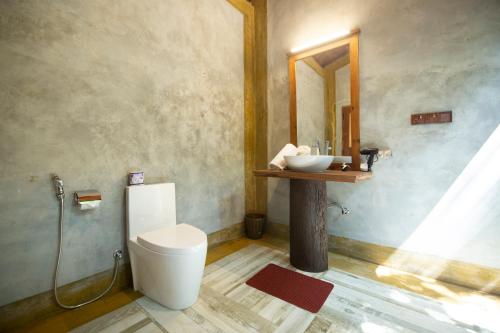 a bathroom with a toilet and a sink at Jungle Shades villa - Habarana in Habarana