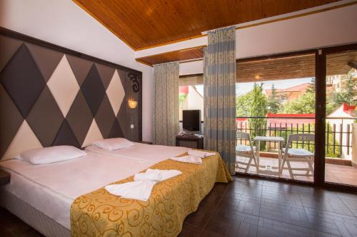 Habitación de hotel con cama y balcón en Villas Elenite, en Elenite