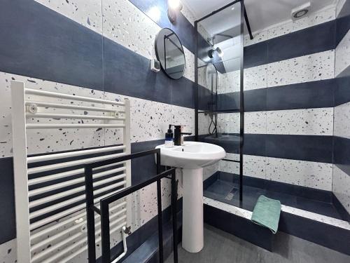 ein blau-weißes Bad mit einem Waschbecken und einem Spiegel in der Unterkunft Pensiunea Florina in Poiana Mărului