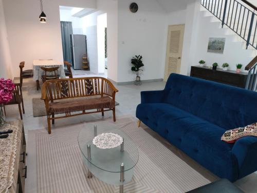 - un salon avec un canapé bleu et des chaises dans l'établissement Sierra Hill Homestay 2, 