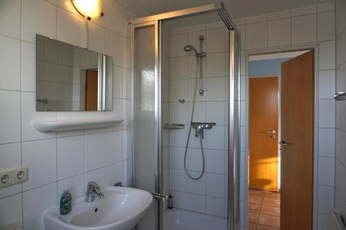 baño blanco con ducha y lavamanos en Ferienwohnung Ostseebrise, Schönberger Strand en Schönberger Strand