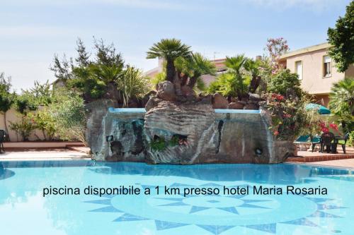 a swimming pool with a fountain in a resort at Apartments with air conditioning in Orosei in Orosei