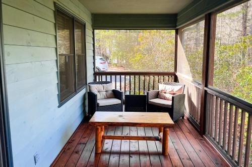 a porch with two chairs and a wooden table at Raven's Respite in Saluda