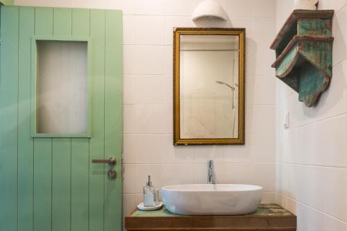 a bathroom with a sink and a green door at Altanure Almatere - Food Forest Boutique Stay in Tavira