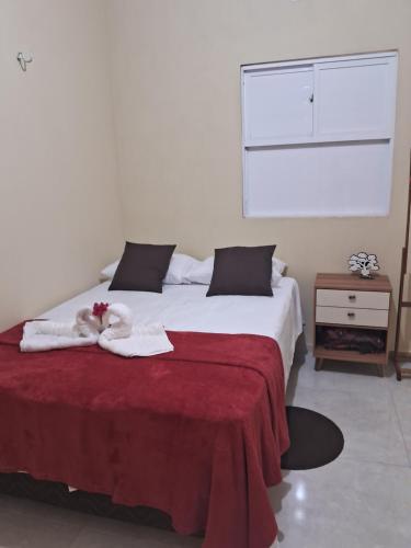 a bedroom with a bed with a stuffed animal on it at Casa vila costeira Guriú in Guriú
