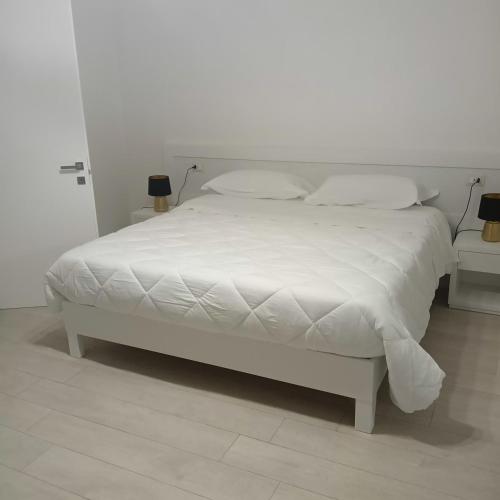 a white bed with white sheets and pillows at mya luxury rooms and wellness in Melendugno