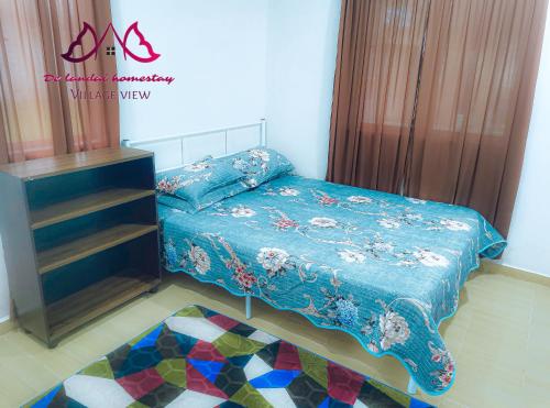 a bedroom with a bed with a blue comforter at D landai homestay in Pekan