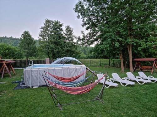 a hammock in a yard with chairs and a table at CONACUL DE SUB MUNTE in Novaci
