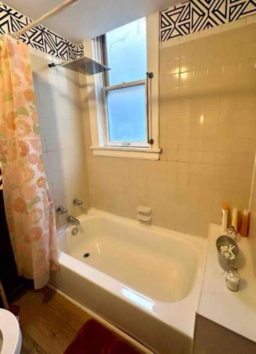 baño con bañera blanca y ventana en Comfy & Modern 3BR Home Free WiFi Free Parking, en Chicago