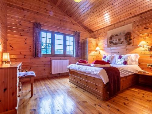 a bedroom with a bed in a log cabin at 4 Bed in Clovelly 00356 in Clovelly