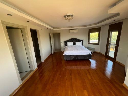 a large bedroom with a bed and a wooden floor at Nefes URLA Villa Sea View. in Urla
