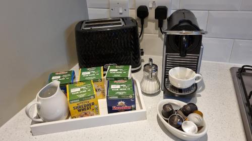 a counter top with a coffee maker and some ingredients at HighTide - 2 bed with parking, balcony & sea view. in Swanage