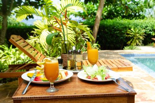 un tavolo con due piatti di cibo e due bicchieri di succo di Zanzi Resort Private Paradise a Zanzibar City