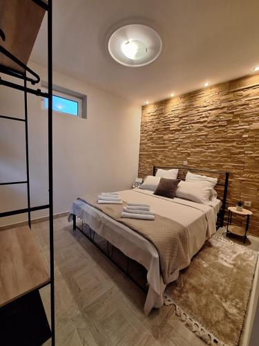ein Schlafzimmer mit einem großen Bett mit Ziegelwand in der Unterkunft City Garden in Sparta