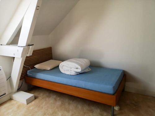 een klein bed met een blauwe matras in een kamer bij Maison de 2 chambres avec piscine partagee et jardin clos a Brantome en Perigord in Brantôme