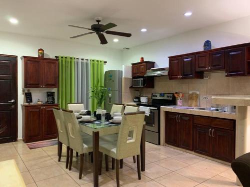cocina con mesa con sillas y ventilador de techo en Casa Suiza – Schweizer Haus, en Liberia