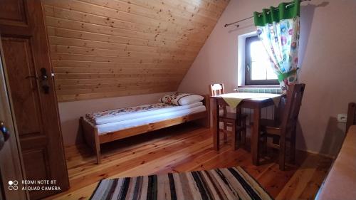 Zimmer mit einem Bett und einem Tisch in einem Zimmer in der Unterkunft Jurajski Domek in Żarki