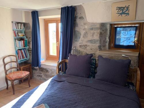a bedroom with a bed with blue curtains and a tv at Tournicolette - 52 m2 charme fou in Chardonne