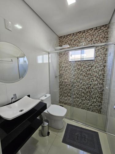 a bathroom with a toilet and a sink and a shower at POUSADA CITRINO in Ametista do Sul