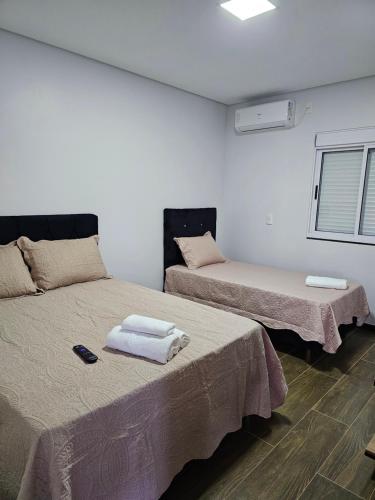 a room with two beds with towels on them at POUSADA CITRINO in Ametista do Sul