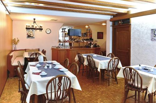 een restaurant met 2 tafels en stoelen en een keuken bij Hotel Garni Sebastian in Kirrweiler