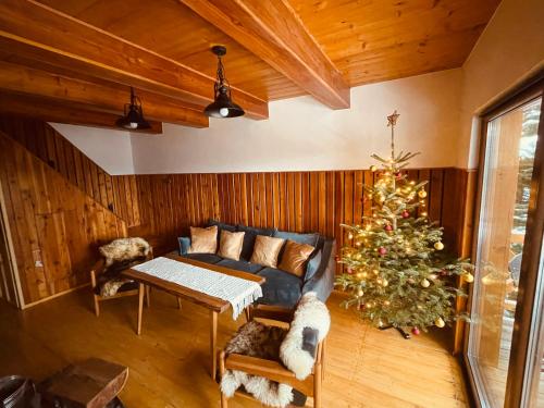 a living room with a christmas tree and a couch at Chata na Soláni in Vsetín