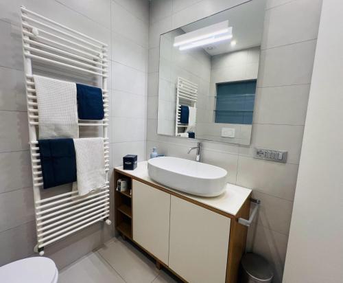 a white bathroom with a sink and a mirror at Appartamento Katy in Viareggio