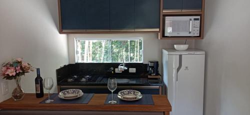 uma cozinha com um balcão com um fogão e um frigorífico em Chalé Lua Azul em Jaraguá do Sul