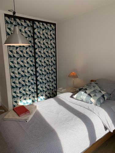 a bedroom with a bed with a blue and white wall at Can Ines in Mauguio