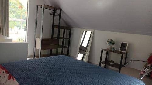 a bedroom with a bed with a blue comforter at Chalé Lua Azul in Jaraguá do Sul