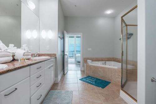 y baño con 2 lavabos, bañera y ducha. en Caribe C104, en Orange Beach