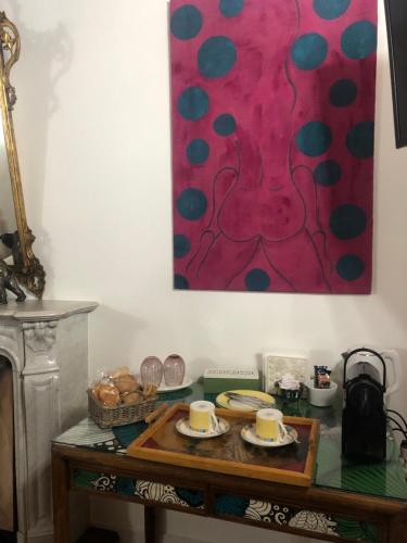 a table with plates of food and a painting on the wall at B&B Villa la Canonica con piscina a Padernello in Farfengo