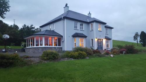 una grande casa bianca con le luci accese di Drummonds House a Sligo