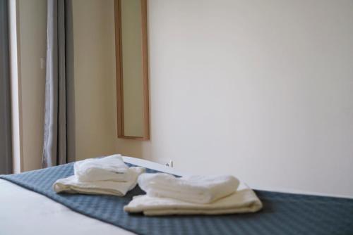 two towels sitting on a bed in a room at Always on the way - Road Home in Montijo, Lisbon in Montijo