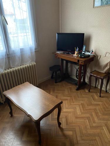 Cette chambre dispose d'un bureau et d'un ordinateur sur une table. dans l'établissement Maison de famille proche Futuroscope, à Châtellerault