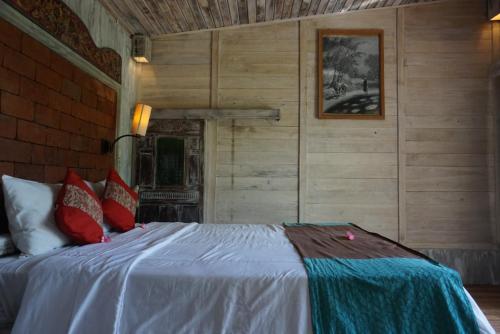 a bedroom with a large bed with wooden walls at Dewa Jati House in Penginyahan
