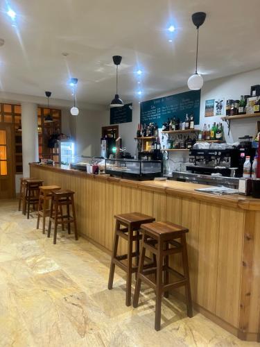 a bar with wooden stools in a restaurant at Bicis & Vacas in La Pola de Gordón
