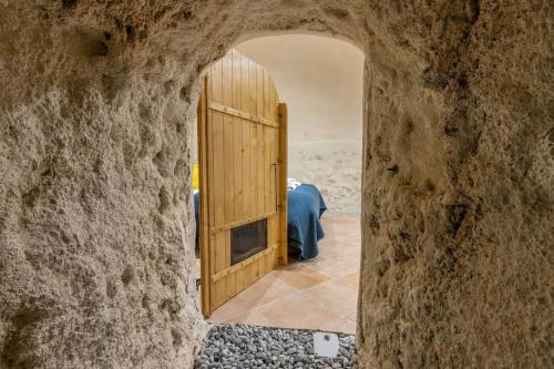 une porte donnant sur un mur de pierre avec une porte en bois dans l'établissement Le Troglogite Mignon - Maison et Jardin, à Amboise