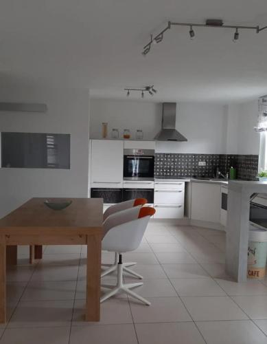 - une cuisine blanche avec une table en bois et une chaise dans l'établissement Hochsalerblick, à Laufenburg