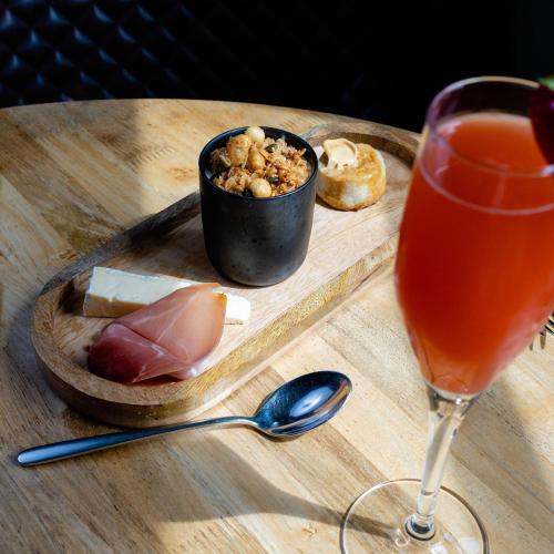 a wooden table with a drink and a plate of food at The Haughmond in Shrewsbury